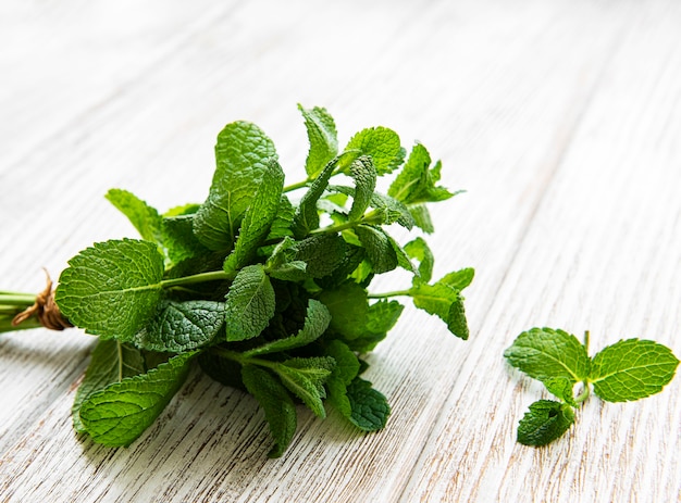 Hojas de menta fresca sobre fondo de madera vieja, endecha plana