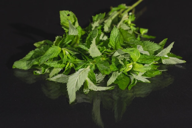 Hojas de menta sobre fondo negro menta sobre la mesa