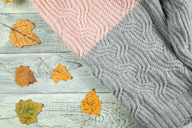 Hojas de otoño amarillas sobre un viejo fondo de madera con textura con una chaqueta con textura