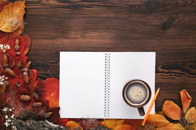 Hojas de otoño, galletas y cuaderno de papel sobre madera