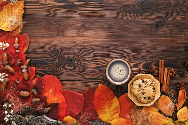 Hojas de otoño, galletas y té en madera