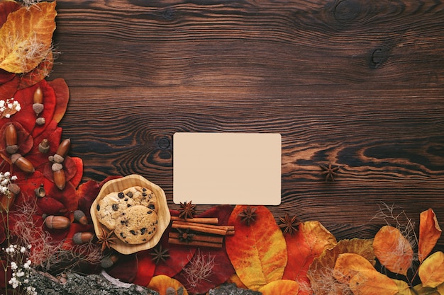 Hojas de otoño, galletas, té y tarjetas de felicitación en madera