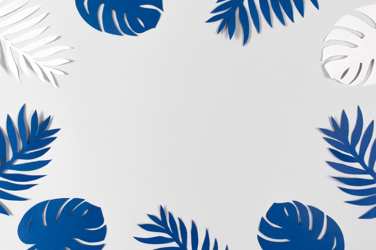 Foto hojas de papel tropical sobre fondo gris. color del año 2020 - azul clásico.