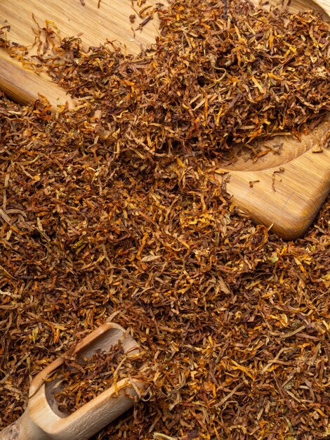 Hojas de tabaco cortadas en seco de alta calidad sobre tablero de madera de fondo de cerca