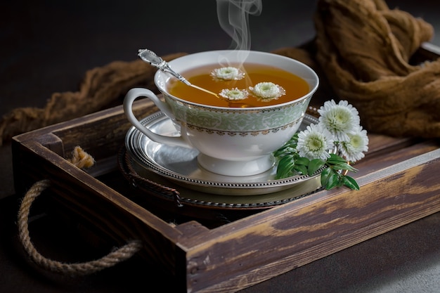 Hojas de té seco sobre una mesa sobre un fondo antiguo