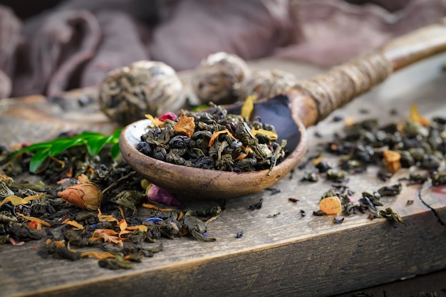 Hojas de té seco sobre una mesa sobre un fondo antiguo