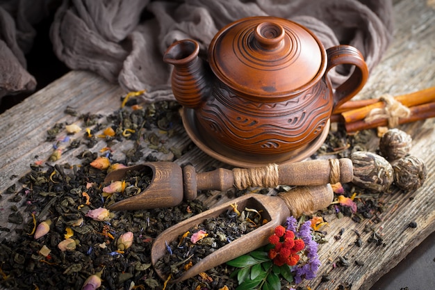 Hojas de té seco sobre una mesa sobre un fondo antiguo