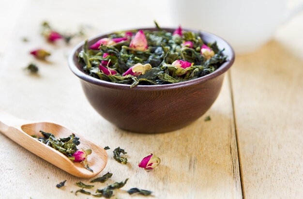 Hojas de té verde con capullos de rosa por tetera