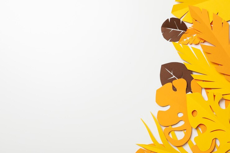 Hojas tropicales de papel amarillo y marrón sobre un fondo claro