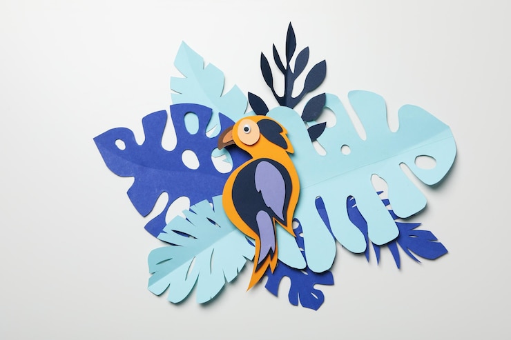Hojas tropicales de papel azul sobre un fondo claro con un loro
