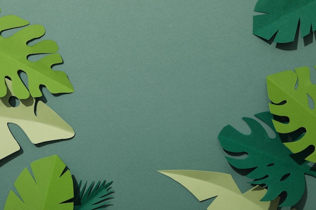 Hojas tropicales de papel verde sobre un fondo verde con un pájaro flamenco