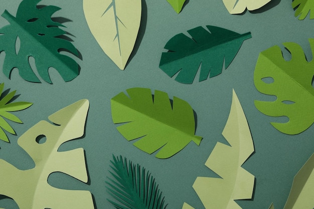 Hojas tropicales de papel verde sobre un fondo verde con un pájaro flamenco