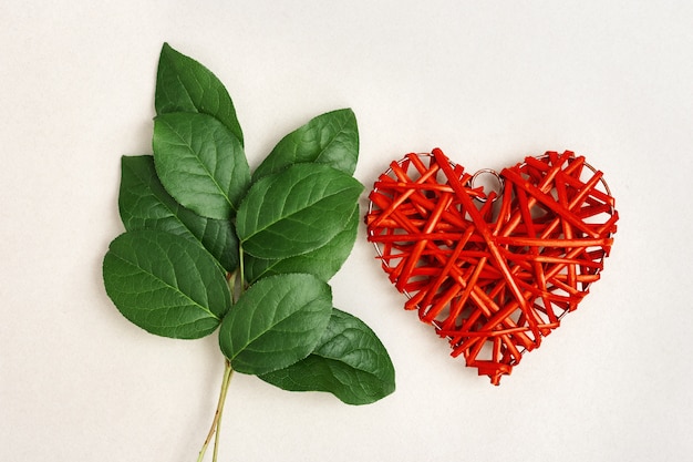 Hojas verdes y corazón rojo de madera