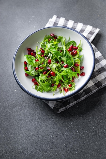 hojas verdes de ensalada de granada, semilla de granada, mezcla de lechuga, comida saludable, refrigerio en la mesa