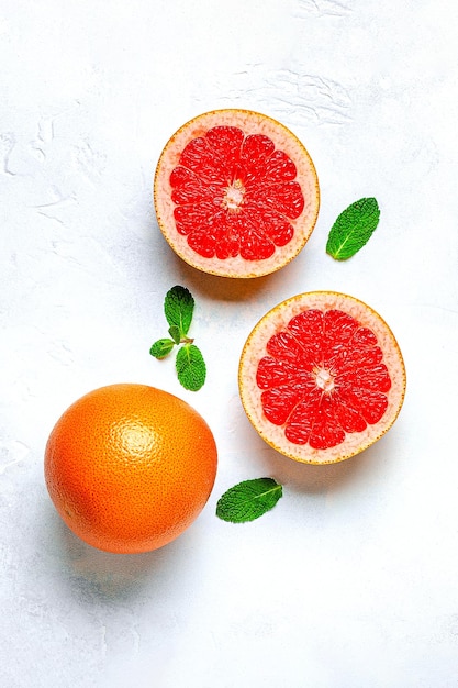 Hojas verdes de pomelo naranja fresco sobre fondo claro vista superior Concepto de jugo de cítricos Frutas de vitamina C