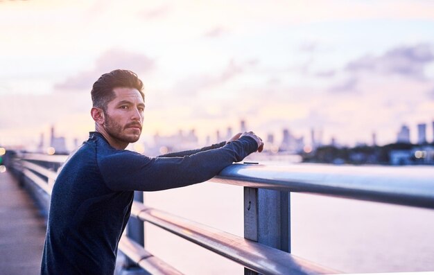 Hoje vou treinar ainda mais forte Foto de um jovem esportivo fazendo uma pausa enquanto se exercita ao ar livre