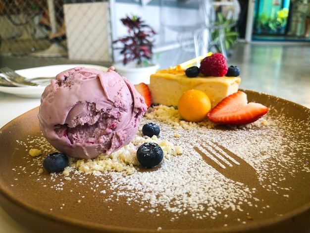 Hokkaido-Käsekuchen auf Teller mit einer Mischung aus Obst und Eis