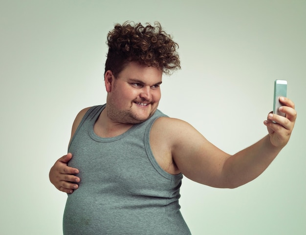 Hola foto sexy de un hombre con sobrepeso tomando una selfie con su teléfono