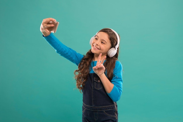 Hola Mundo. Videollamada. Niña pequeña con smartphone. Niña pequeña con teléfono móvil. Niño aprendiendo nuevas tecnologías. Usuario de tecnología de teléfono móvil lindo. Ver video en un dispositivo móvil.