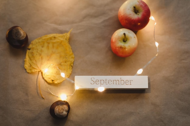 Hola tarjeta de otoño de septiembre con manzanas rojas frescas en la vista superior de fondo blanco