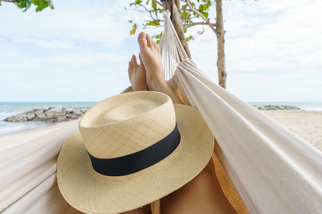 Hola verano hombre relajándose en una hamaca bronceándose en la playa feliz tomando el sol durante las vacaciones de verano. en vacaciones tropicales.