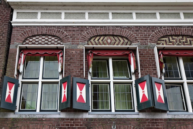 Holanda, pueblo de Volendam (Amsterdam), antigua fachada de casa de piedra y ventanas holandesas típicas