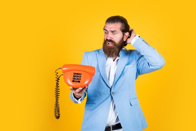 Foto holen sie sich ihr telefon heute repariert leitung ist beschäftigt fellow on the phone junger mann spricht am telefon geschäftsmann spricht über vintage-telefon männlich spricht über festnetz-telefon vintage-technologie im modernen leben