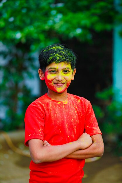 Holi-Feierlichkeiten - Indischer kleiner Junge, der Holi spielt und Gesichtsausdruck zeigt.