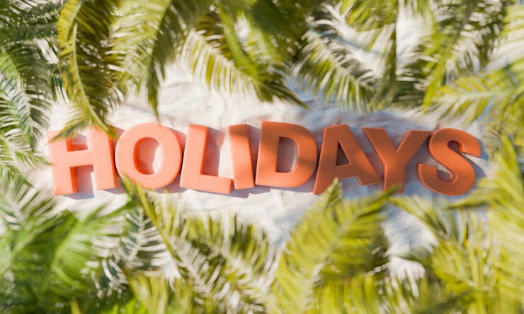 Foto holidays texto en el suelo de la playa de arena con hojas de palma alrededor
