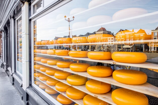 Holländische Käseköpfe in den Regalen der Vitrine mit Reflexion der Stadt Delft in den Niederlanden