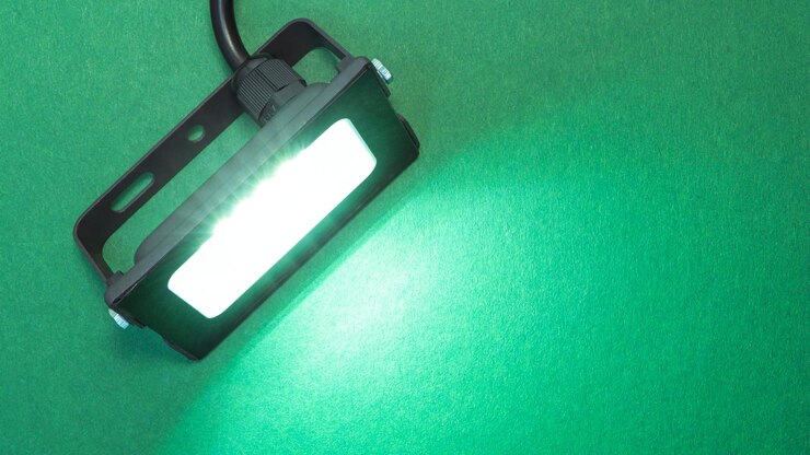 Foto holofote de diodo luminoso dispositivo de iluminação tecnologias modernas de economia de energia fundo verde brilhante iluminado copiar espaço para texto