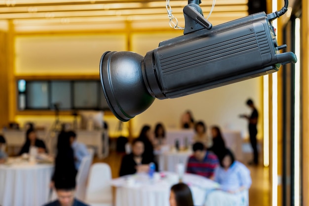 Holofote LED na sala de aula do seminário com pessoas desfocadas atrás