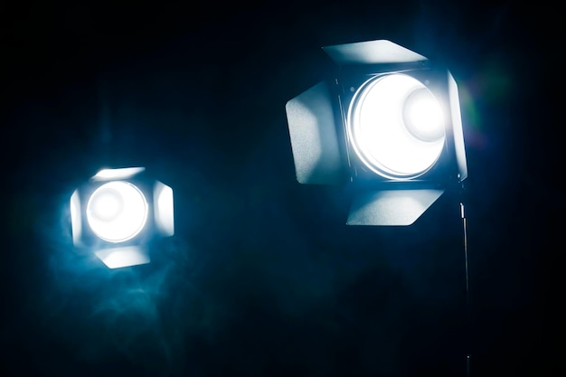 Foto holofotes brilhantes e fumaça na escuridão equipamento de palco profissional