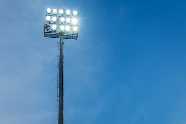 Holofotes na noite de céu azul de estádio