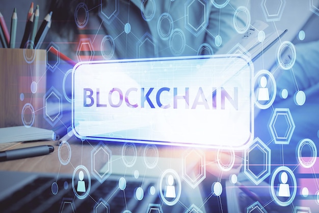 Holograma de criptomoneda sobre las manos de la mujer escribiendo fondo Concepto de blockchain Exposición múltiple