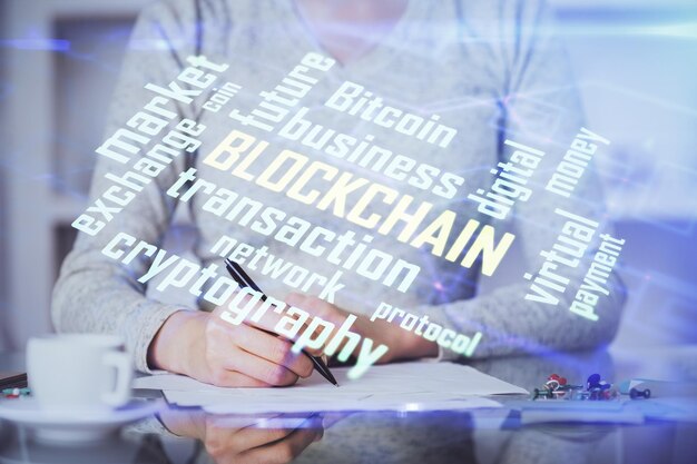 Holograma de criptomoneda sobre las manos de una mujer escribiendo el fondo Concepto de blockchain Exposición múltiple