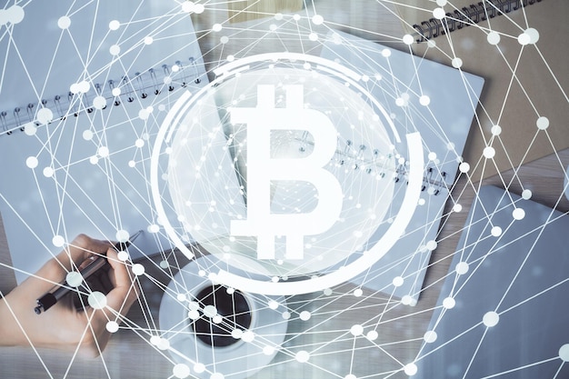 Holograma de criptomoneda sobre las manos de la mujer escribiendo fondo Concepto de cadena de bloques Doble exposición