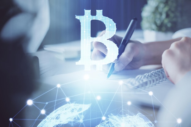 Holograma de criptomoneda tema de bitcoin ico sobre las manos tomando notas de fondo Concepto de blockchain Exposición múltiple