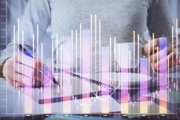 Holograma de gráfico Forex na mão tomando notas de fundo Conceito de análise Dupla exposição