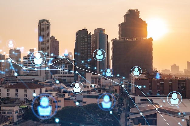 Holograma de ícones de mídia social sobre a paisagem urbana panorâmica do pôr do sol de Bangkok Sudeste Asiático O conceito de conexões de pessoas e oportunidades de carreira Multi exposição