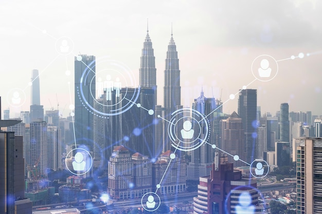 Holograma de ícones de mídia social sobre a vista panorâmica da cidade de Kuala Lumpur Malásia Ásia O conceito de conexões de rede de pessoas e oportunidades de carreira Dupla exposição