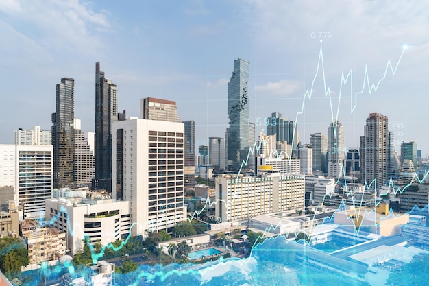 Holograma de gráfico de acciones financieras sobre la vista panorámica de la ciudad del centro de negocios de Bangkok en el sudeste asiático El concepto de transacciones internacionales Doble exposición