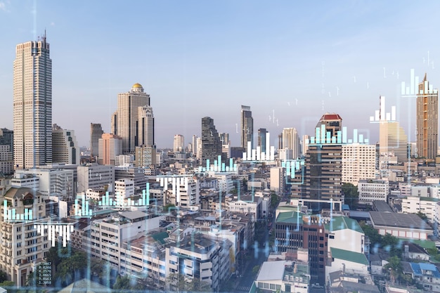 Holograma de gráfico de acciones financieras sobre la vista panorámica de la ciudad del centro de negocios de Bangkok en el sudeste asiático El concepto de transacciones internacionales Doble exposición