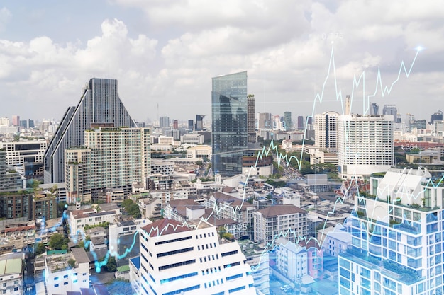 Holograma de gráfico de divisas y mercado de valores sobre la vista panorámica de la ciudad de Bangkok, el centro financiero en el sudeste asiático El concepto de comercio internacional Doble exposición
