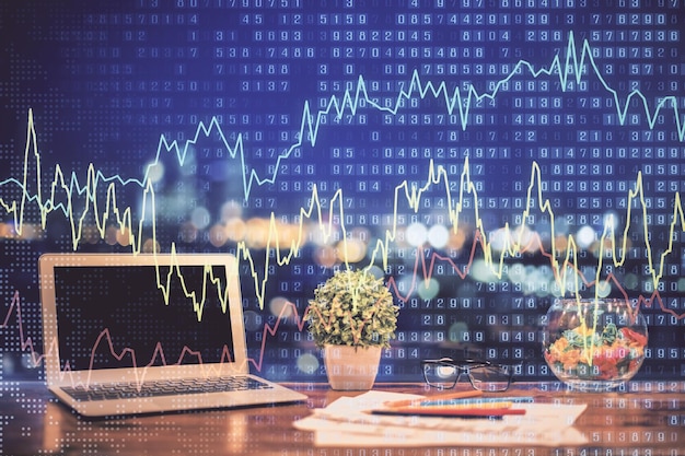 Holograma de gráfico de divisas en la mesa con fondo de computadora Doble exposición Concepto de mercados financieros