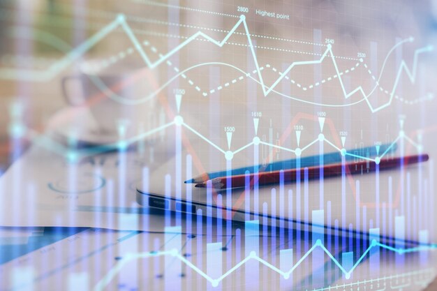 Holograma de gráfico de divisas en la mesa con fondo de computadora Doble exposición Concepto de mercados financieros