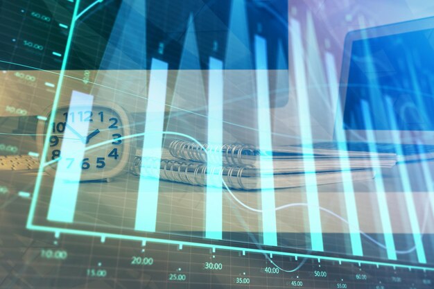 Holograma de gráfico de divisas en la mesa con fondo informático Múltiple exposición Concepto de mercados financieros