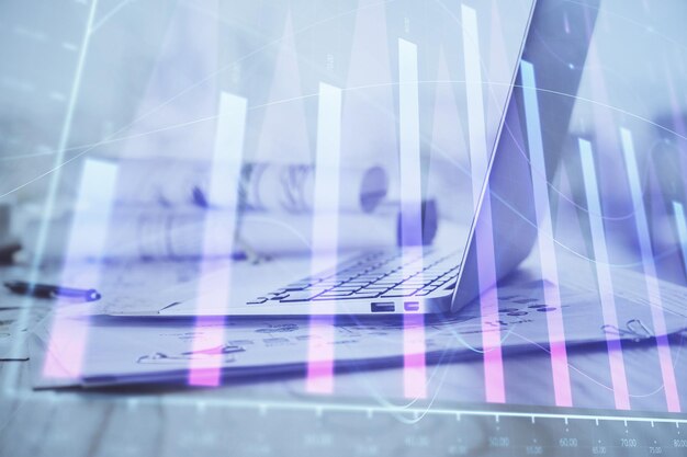 Holograma de gráfico de divisas en la mesa con fondo informático Múltiple exposición Concepto de mercados financieros