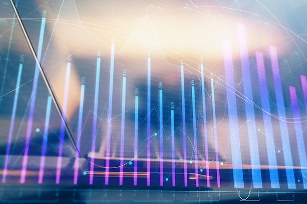 Holograma de gráfico de divisas en la mesa con fondo informático Múltiple exposición Concepto de mercados financieros
