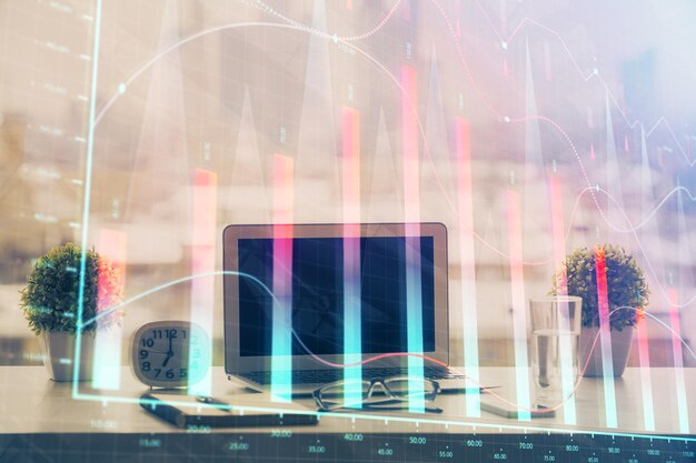 Holograma de gráfico de divisas en la mesa con fondo informático Múltiple exposición Concepto de mercados financieros
